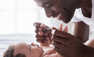 אבא מחזיק בידיים של תינוק (צילום: By Dafna A.meron, shutterstock)
