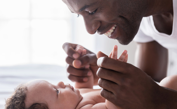 אבא מחזיק בידיים של תינוק (צילום: By Dafna A.meron, shutterstock)
