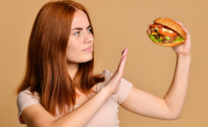 אישה מחזיקה המבורגר (צילום:  Fab_1, shutterstock)