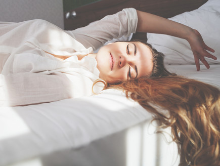 אישה שוכבת במיטה (צילום: y Leszek Glasner, shutterstock)