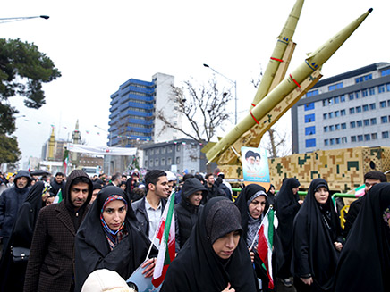 אנשים בעצרת חולפים ליד טילים (צילום: AP, חדשות)