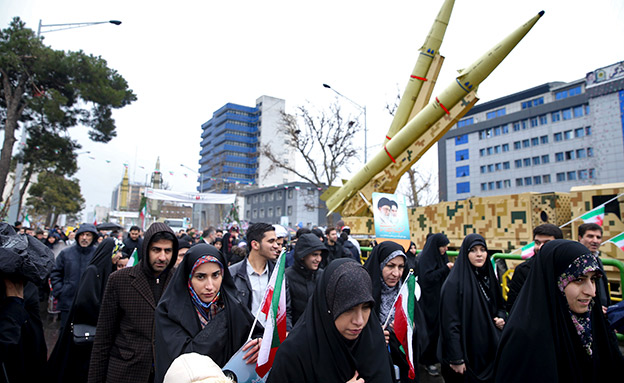אנשים בעצרת חולפים ליד טילים (צילום: AP, חדשות)