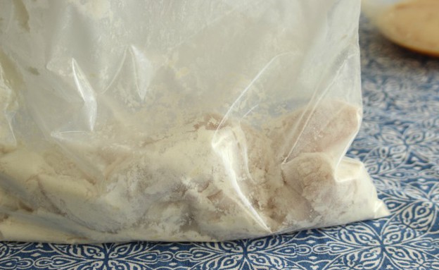 מכניסים את רצועות חזה העוף לשקית עם קמח