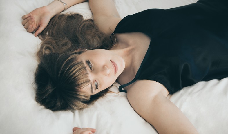 אישה שוכבת על מיטה (אילוסטרציה: unsplash)