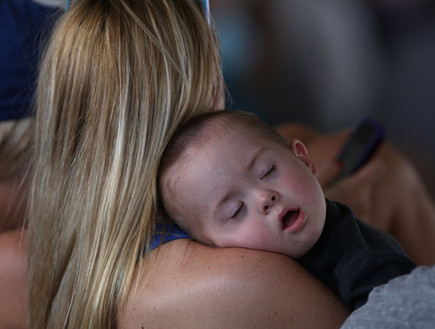 תינוק ישן על אימו במהלך משחק בייסבול בשיקגו (צילום: Jonathan Daniel, Getty Images)