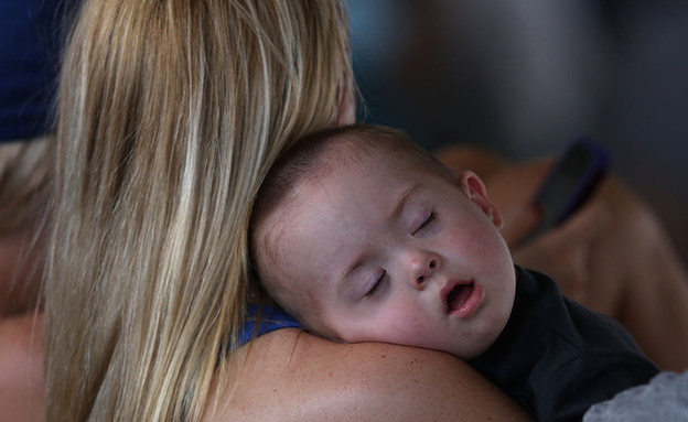 תינוק ישן על אימו במהלך משחק בייסבול בשיקגו (צילום: Jonathan Daniel, Getty Images)