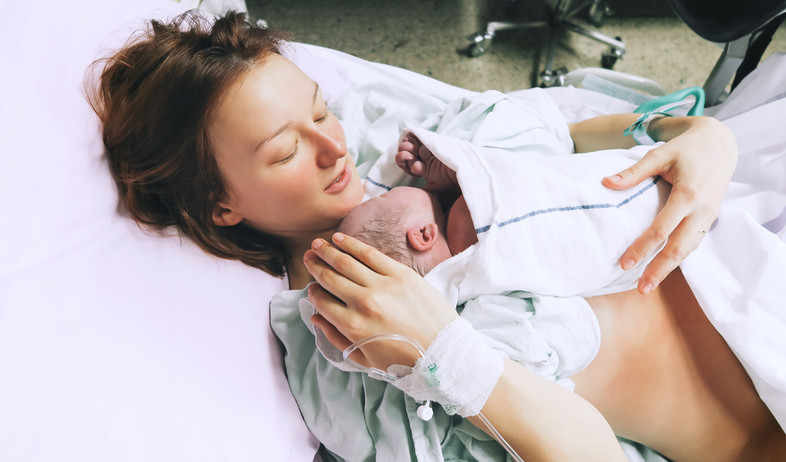 אמא מחזיקה תינוק אחרי לידה בבית החולים (צילום: By Dafna A.meron, shutterstock)