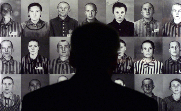 איש מתבונן בתמונות של נספים בשואה (צילום: רויטרס, חדשות)