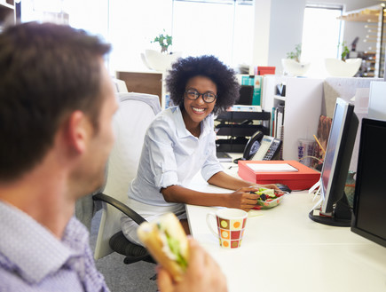 עובדים אוכלים במשרד (צילום: Monkey Business Images, ShutterStock)