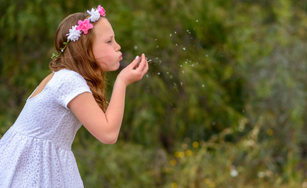 ילדה עם זר פרחים בשדה (אילוסטרציה: By Dafna A.meron, shutterstock)