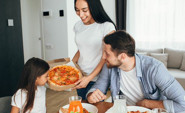 משפחה אוכלת פיצה (אילוסטרציה: By Dafna A.meron, shutterstock)