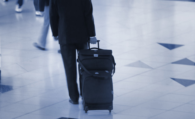 איש סוחב מזוודה בשדה התעופה (צילום: אימג'בנק / Thinkstock)