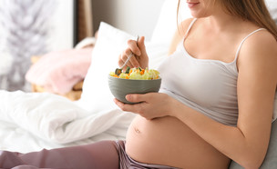 אישה בהיריון אוכלת סלט פירות במיטה (אילוסטרציה: Pixel-Shot, shutterstock)