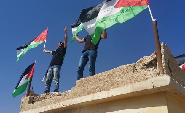 מפגינים פלסטינים מניפים דגל על הלידו בצפון ים המלח (צילום: Christine and Steve Tan, D-MARS, המרכז הישראלי למשימות אנלוגיות במאדים)