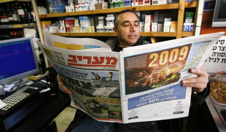 בעל קיוסק קורא עיתון, 2009 (צילום: מרים אלסטר, פלאש 90)