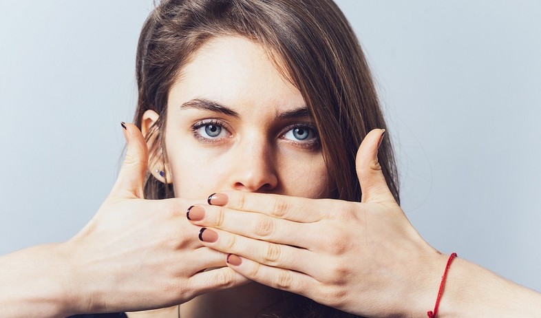 אישה שמה יד על הפה (צילום: Shutterstock)