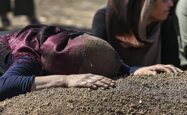 כורדית בסוריה על קברו של בן משפחתה (צילום: Sakchai Lalit | AP)