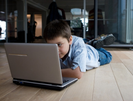 ילד שוכב מול מחשב נייד