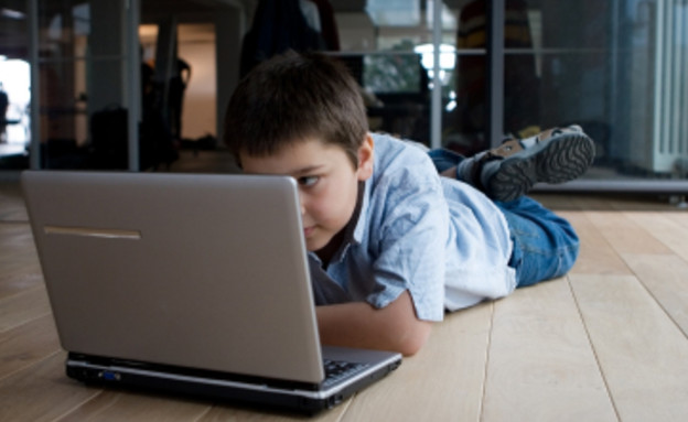 ילד שוכב מול מחשב נייד (צילום: istockphoto)