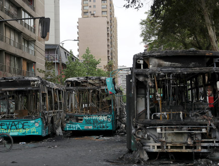 אוטובוסים שהוצתו במהלך ההפגנות בסנטיאגו (צילום: רויטרס)