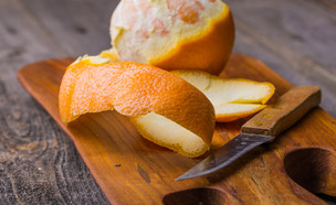 תפוז מקולף על קרש חיתוך (צילום:  Milosz_G, shutterstock)