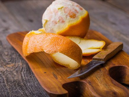 תפוז מקולף על קרש חיתוך (צילום:  Milosz_G, shutterstock)