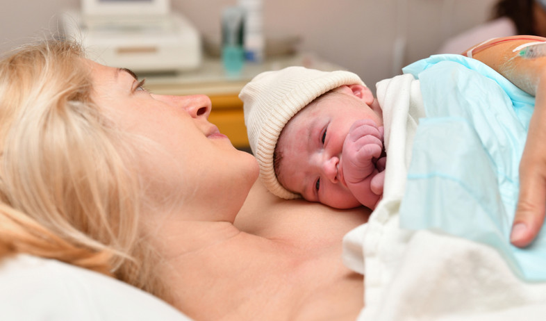 אמא מחבקת תינוק בחדר לידה (אילוסטרציה: kipgodi, shutterstock)