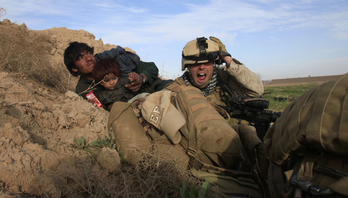חייל אמריקאי מגן על אב ובנו האפגנים במתקפת טאליבן (צילום: Goran Tomasevic, רויטרס_)
