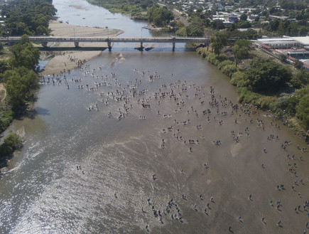 מאות המהגרים שחוצים את הנהר בגואטמלה, לעבר מקסיקו (צילום: AP)