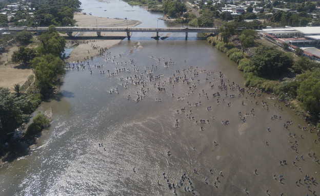 מאות המהגרים שחוצים את הנהר בגואטמלה, לעבר מקסיקו (צילום: AP)