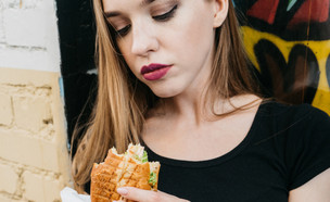 אישה אוכלת ג'אנק (צילום:  Dragon_Fly, shutterstock)