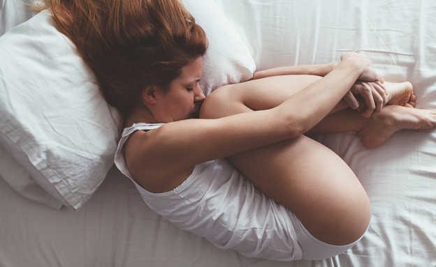 אישה עצובה שוכבת על מיטה (אילוסטרציה: Marjan Apostolovic, shutterstock)