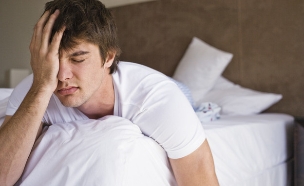 בחור עייף מתעורר משינה ותופס את הראש (צילום: jupiter images)