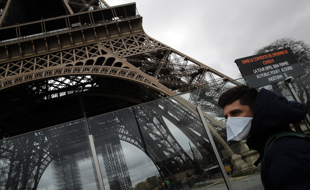 גבר במסכה ליד מגדל אייפל בפריז הסגור בשל הקורונה ( (צילום: Christophe Ena, getty images)