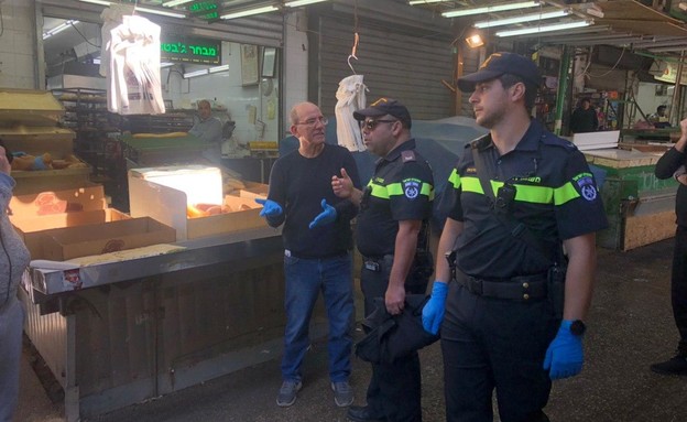 שוטרים סוגרים בסטות בשוק הכרמל (צילום: החדשות12)