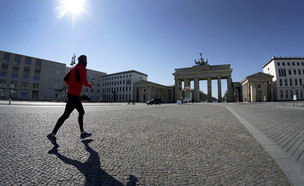 גבר רץ בשער ברנדנבורג ריק מאנשים, ברלין (צילום: Michael Sohn, AP)