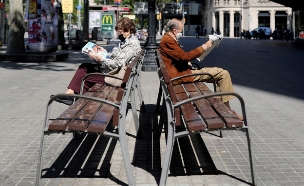 זוג מבוגרים קוראים עיתון עם מסיכות הגנה, ברצלונה (צילום: reuters)