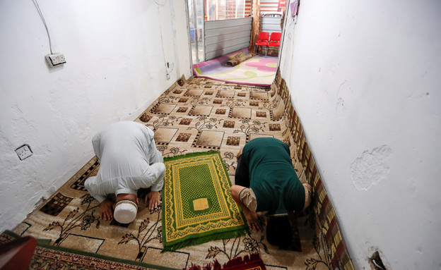 מתפללים ברמאדן בחנות, לאור סגירת המסגדים בעירק (צילום: reuters)