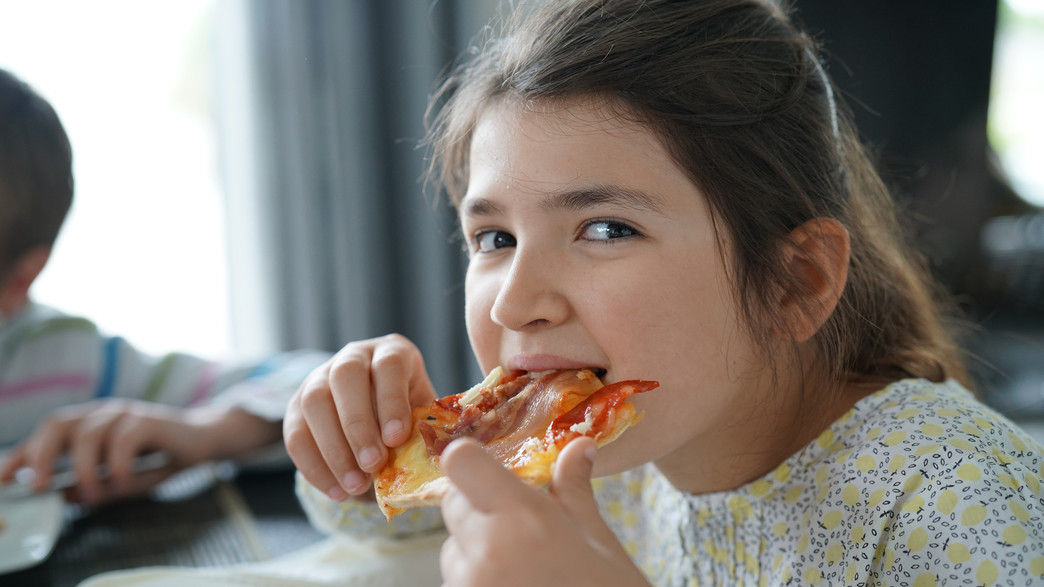 ילדה אוכלת פיצה (צילום: shutterstock_goodluz)