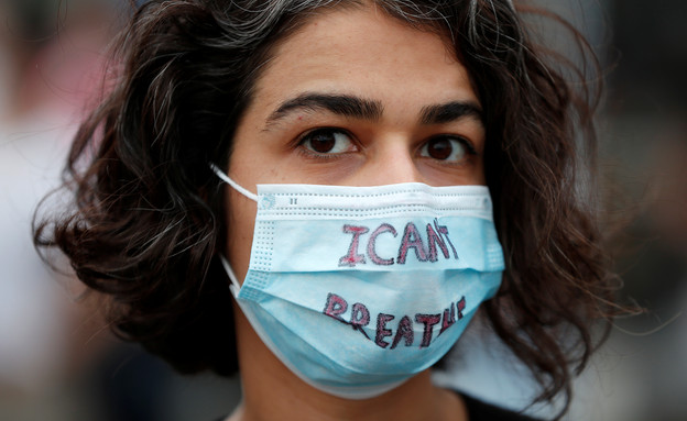 מפגינה עוטה מסכה עם הכיתוב "אני לא יכול לנשום", מי (צילום: רויטרס_)