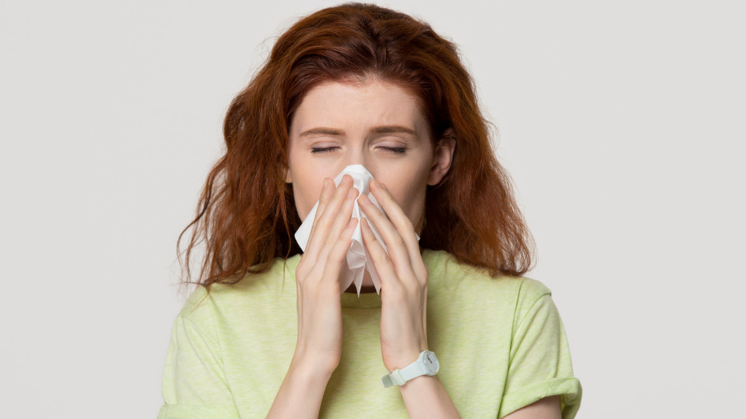 אישה מקנחת את האף