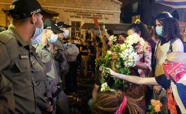 מפגינים מחלקים פרחים לשוטרים
