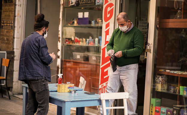 אדם במסיכה קונה טבק בחנות באיסטנבול (צילום: vy.studio, shutterstock)