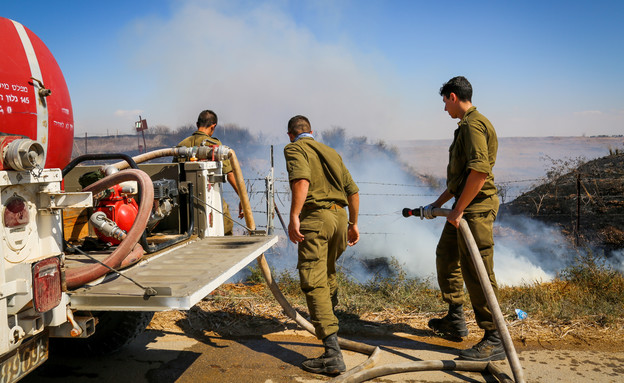 חיילים מכבים שרפה ליד קיבוץ בארי (צילום: פלאש/90 )