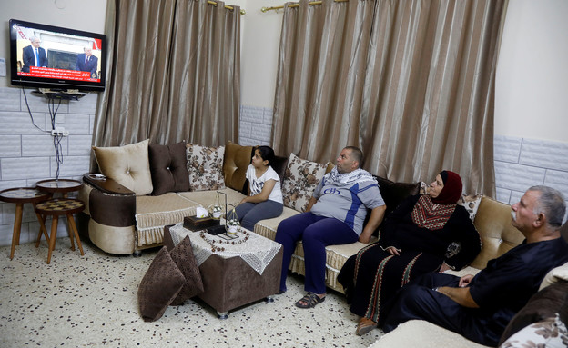 פלסטינים צופים בחתימת ההסכם ההיסטורית בביתם (צילום: AP)
