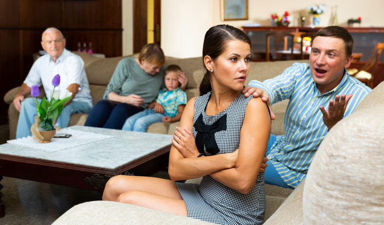 אישה צעירה עצבנית אחרי ריב עם בעלה מול ההורים (אילוסטרציה: Iakov Filimonov, Shutterstock)