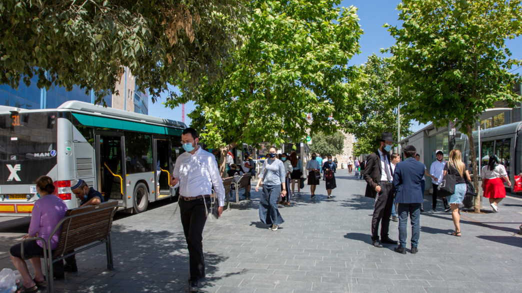 אנשים במסיכות ליד תחנת אוטובוס בירושלים (צילום: Alex Eidelman, shutterstock)