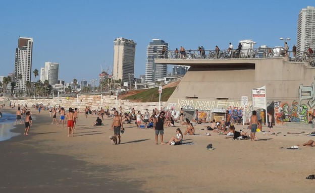 מתרחצים בחוף הים בתל אביב בניגוד להנחיות (צילום: N12)