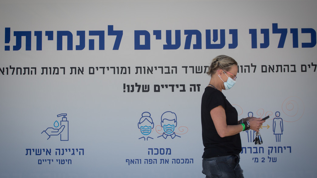 אישה עם מסכה על רקע הנחיות הקורונה
