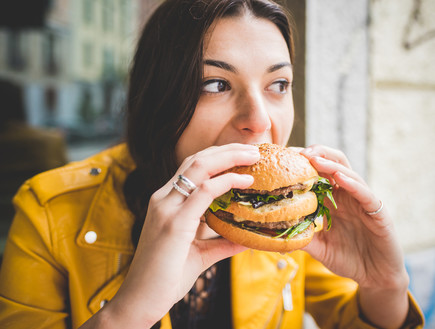 אישה אוכלת המבורגר (צילום:  Eugenio Marongiu, shutterstock)